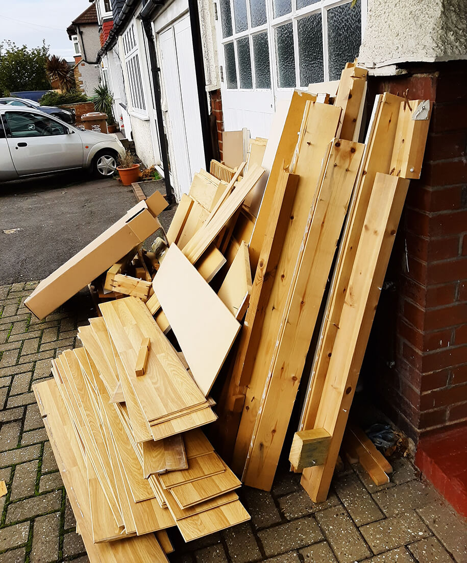 Vor einem Haus liegt Holzabfall